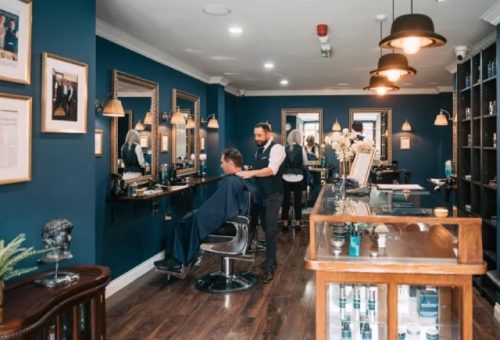 Beautiful barbershop with three barbers cutting clients hair